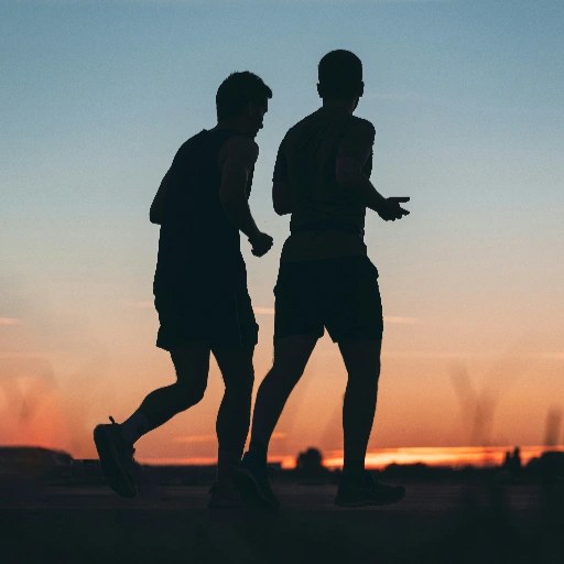 Two runners training together at sunset